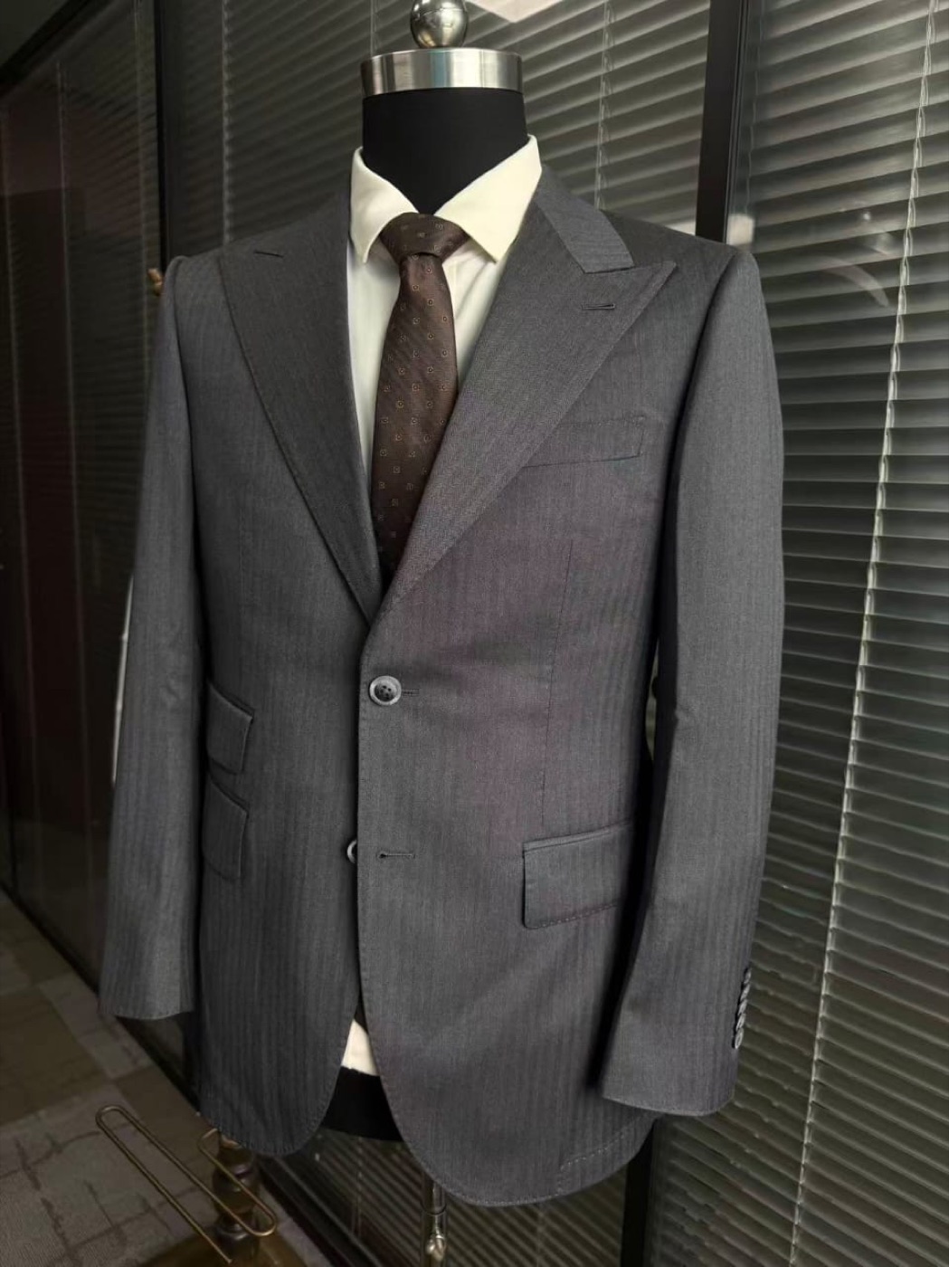 Grey herringbone suit with brown tie